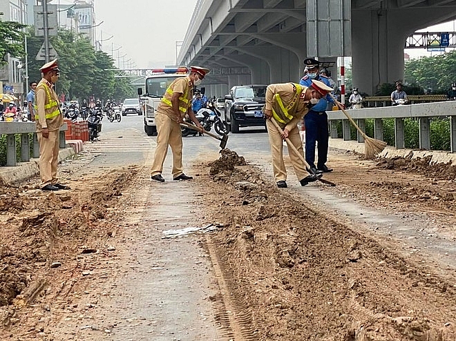 Lực lượng chức năng dọn bùn đất. Ảnh: ANTĐ