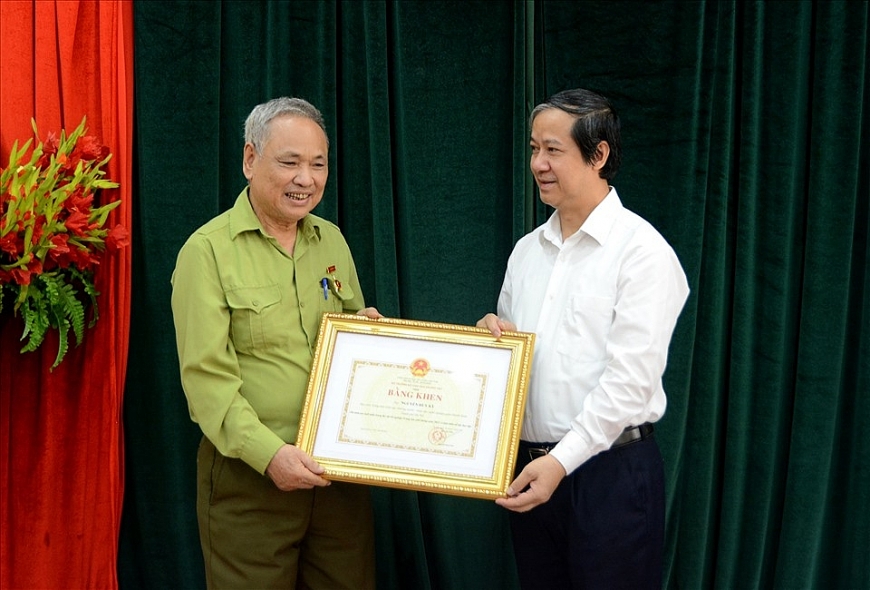 Bộ trưởng Bộ GDĐT Nguyễn Kim Sơn tặng Bằng khen cho ông Nguyễn Huy Kỳ - thí sinh 82 tuổi vừa thi đỗ kỳ thi tốt nghiệp THPT năm 2022. Ảnh: MOET